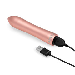 Doxy Bullet Vibrator lying on its side connected to a USB charging cable, showing magnetic port