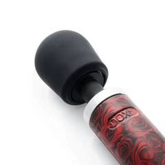 Close-up of Doxy wand's rounded black silicone head and chrome neck with rose-print grip