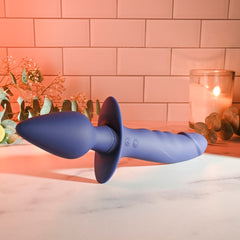 Dual Defender resting horizontally on marble countertop with warm candlelight background