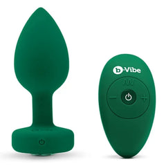 Emerald green silicone anal plug beside matching b-Vibe wireless remote control