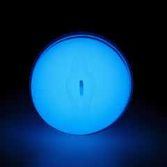 Close-up of Feel Glow stroker entry opening glowing blue in the dark, showing discreet oval-shaped opening