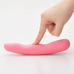 Finger pressing flexible body of pink Iroha Fit vibrator showing pliable silicone