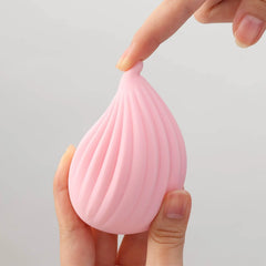 Finger pressing the tip of the Iroha Kushi pink silicone vibrator demonstrating soft flexible material