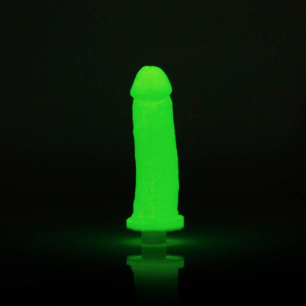 Finished Clone A Willy silicone replica glowing bright green in a darkened room with vibrator base