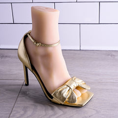 Foot stroker displayed upright wearing gold stiletto heel to show lifelike foot shape
