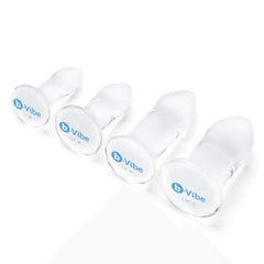 Four clear glass anal dilators displayed base-up, showing b-Vibe logo and diameter measurements