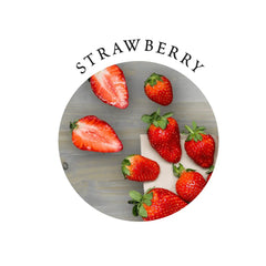 Fresh whole and sliced strawberries on wood surface showing the gift set's natural strawberry flavor