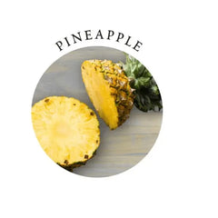 Freshly cut pineapple slices on a wood surface representing the gift set's natural pineapple scent
