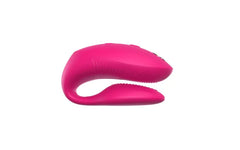 Front-facing view of electric pink C-shaped couples vibrator with textured stimulation tip