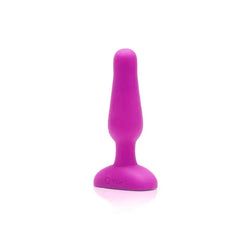Fuchsia b-Vibe silicone anal plug standing upright, smooth tapered shape detail