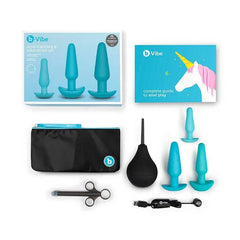 Full b-Vibe Anal Training & Education Set contents laid flat including plugs, bulb, launcher, pouch, and guide