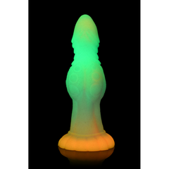 Galactic Cock dildo glowing green and amber in complete darkness after UV light activation