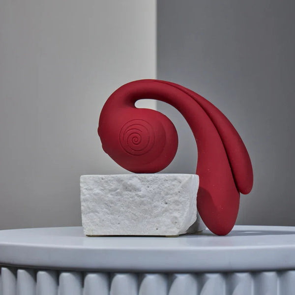 Gizi Pro triple stimulator displayed upright on white stone block, showing full elegant form