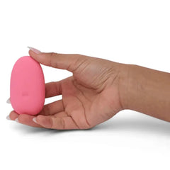 Hand cradling pink ILY Pebble vibrator from below, showing rounded smooth base