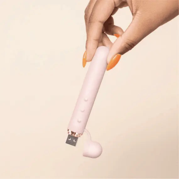 Hand demonstrating USB charging port on Le Wand Baton with silicone cap removed