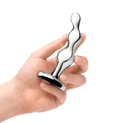 Hand gripping b-Vibe stainless steel anal beads upright, demonstrating compact grip size