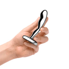 Hand gripping b-Vibe stainless steel prostate plug to demonstrate compact size and grip