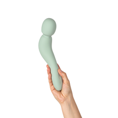 Hand gripping Dame Com 2.0 Wand upright, demonstrating comfortable handle length and grip