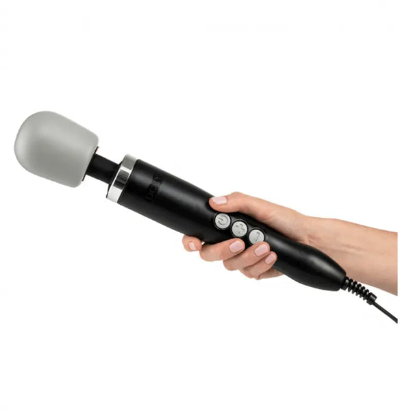 Hand gripping the Doxy Original black wand massager, showing ergonomic handle and corded base