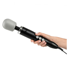 Hand gripping the Doxy Original black wand massager, showing ergonomic handle and corded base