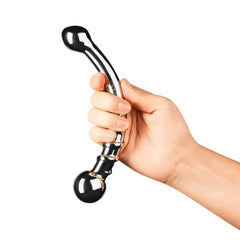 Hand gripping Le Wand Bow stainless steel dildo by ridged section showing scale and larger end up