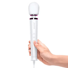 Hand gripping Le Wand Petite Plug-In Massager handle, showing ergonomic size and control buttons