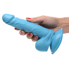 Hand gripping Pop Peckers blue realistic dildo showing suction base and textured shaft