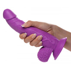 Hand gripping the Pop Peckers purple dildo, showing realistic texture and flexible shaft