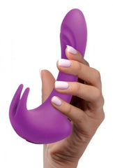 Hand gripping purple 12X Lux Rocker rabbit vibrator upright, showing dual-stimulation prong and shaft shape