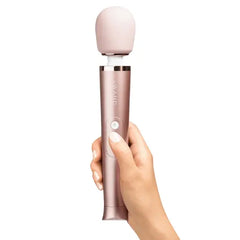 Hand gripping the rose gold Le Wand Petite Massager to show ergonomic handle size