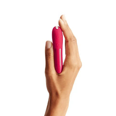 Close-up of hand gripping Tango X bullet vibrator, silver control button visible on top