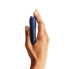 Hand gripping Tango X showing side control buttons and silver power button on top