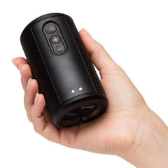 Hand holding the Arcwave Zing stroker face-up, showing power button, intensity controls, and LED indicators
