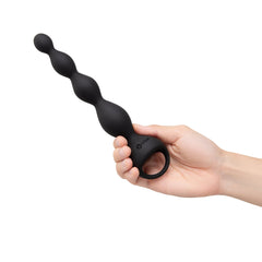 Hand holding b-Vibe 6.5" Vibing Beads upright, showing ergonomic finger-loop handle grip
