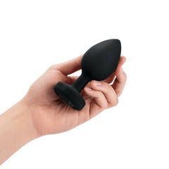 Hand holding b-Vibe Jewel Plug XXL to show compact size of the black silicone plug