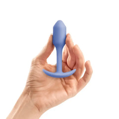 Hand holding b-Vibe Snug Plug 1 in violet to illustrate its compact beginner size