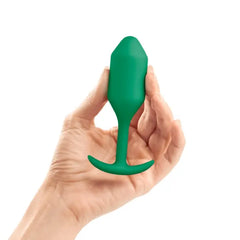 Hand holding b-Vibe Snug Plug 2 green silicone plug to illustrate compact size