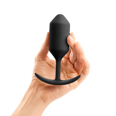 Hand holding b-Vibe Snug Plug 3 black silicone weighted anal plug to illustrate size and scale