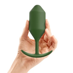 Hand holding b-Vibe Snug Plug 4 in army green to illustrate size scale of weighted plug