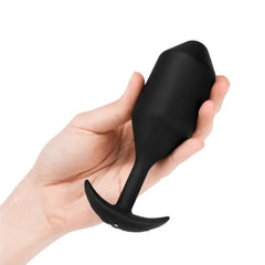 Hand holding b-Vibe Snug Plug 5 showing scale of large weighted black silicone plug
