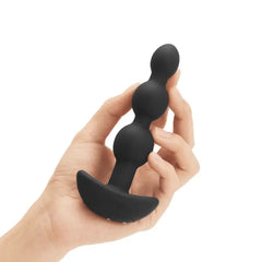 Hand holding b-Vibe Triplet Anal Beads to show compact, palm-sized scale