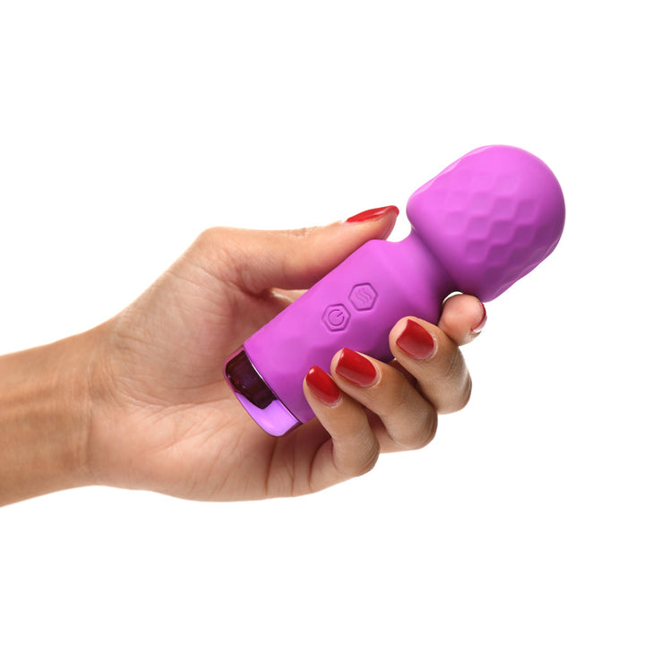 Hand holding the Bang 10X Mini Silicone Wand vibrator in purple, showing compact size