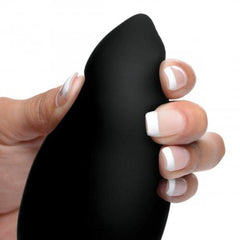 Close-up of a hand holding the black silicone Taper anal plug, showing its soft flexible curved tip