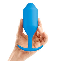 Hand holding blue b-Vibe Snug Plug 5 large weighted silicone plug to show size reference