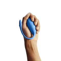 Hand holding blue We-Vibe Jive egg vibrator, demonstrating its compact, palm-fitting flexible form