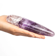 Hand holding the Chakrubs amethyst crystal wand, showing its tapered length and natural stone finish