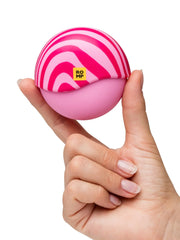 Hand holding closed ROMP Spin sphere displaying pink and magenta swirl pattern