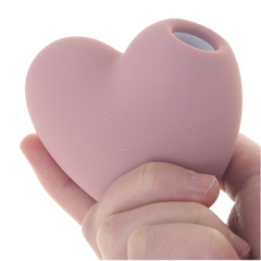 Hand holding the Cutie Heart stimulator, showing compact heart shape and soft matte silicone texture