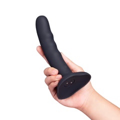 Hand holding dark grey silicone curved dildo, showing ridged shaft and charging port on base