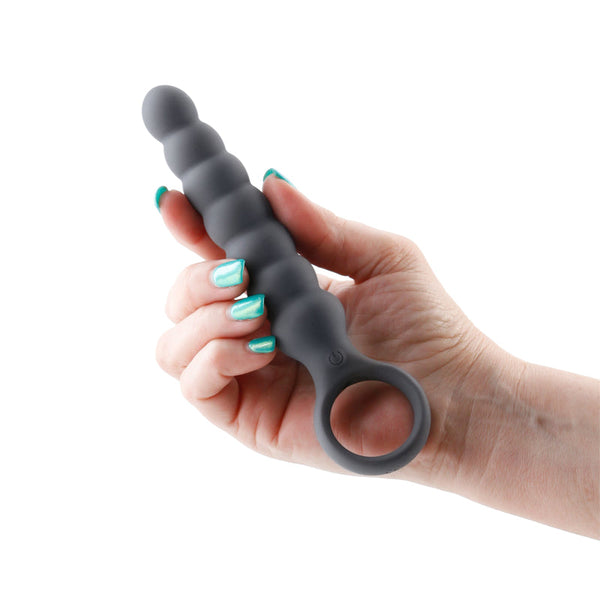 Hand holding Desire Lucent Vibrating Wand in smoke grey silicone with beaded shaft and ring base